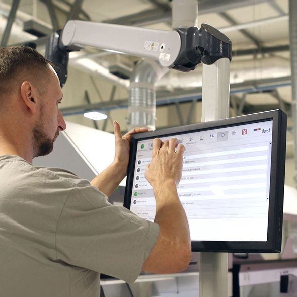 Un collaboratore controlla una macchina da stampa nello stabilimento di produzione bannerstop